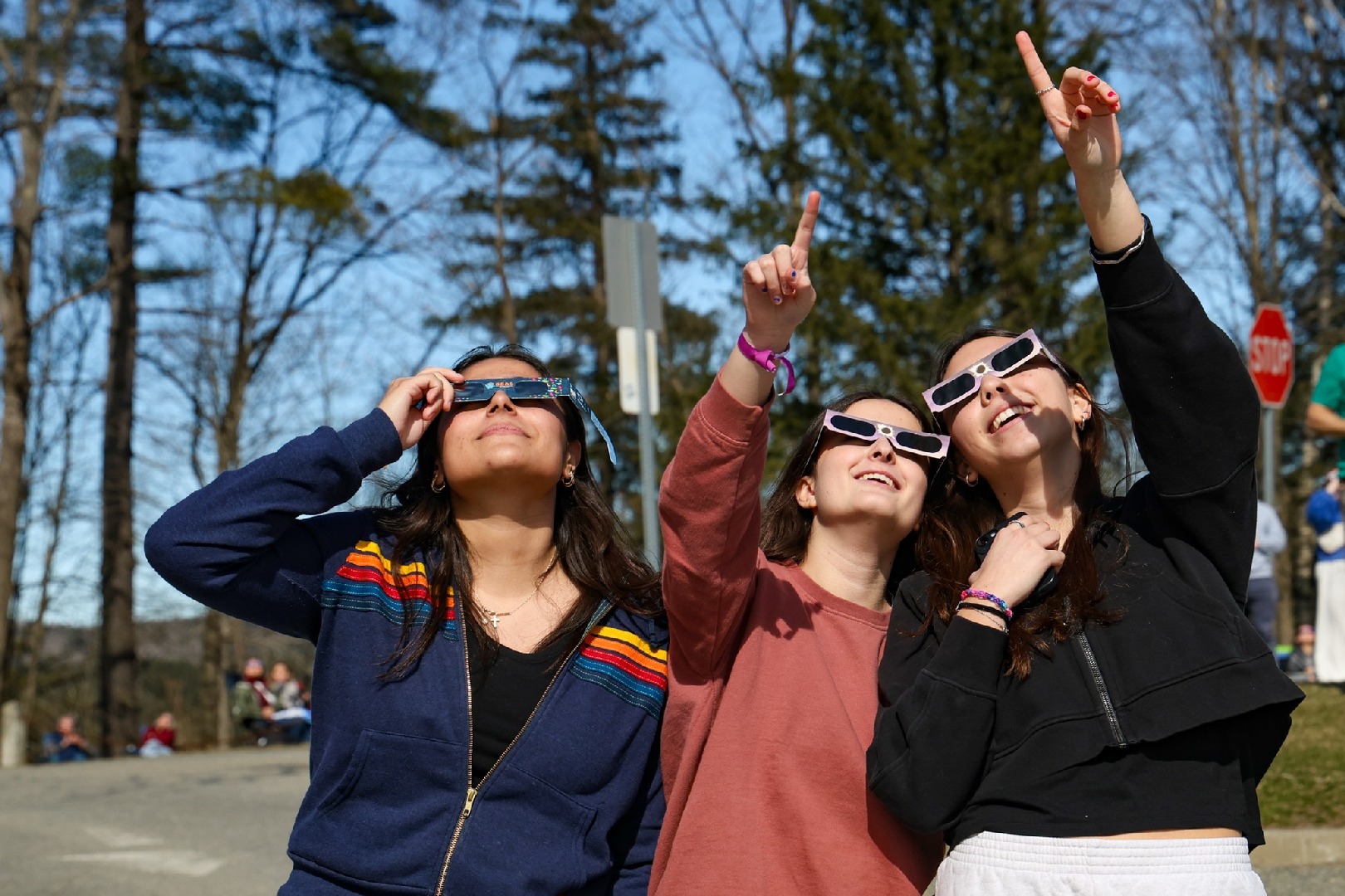 Jugendliche beobachten mit Schutzbrillen eine Sonnenfinsternis